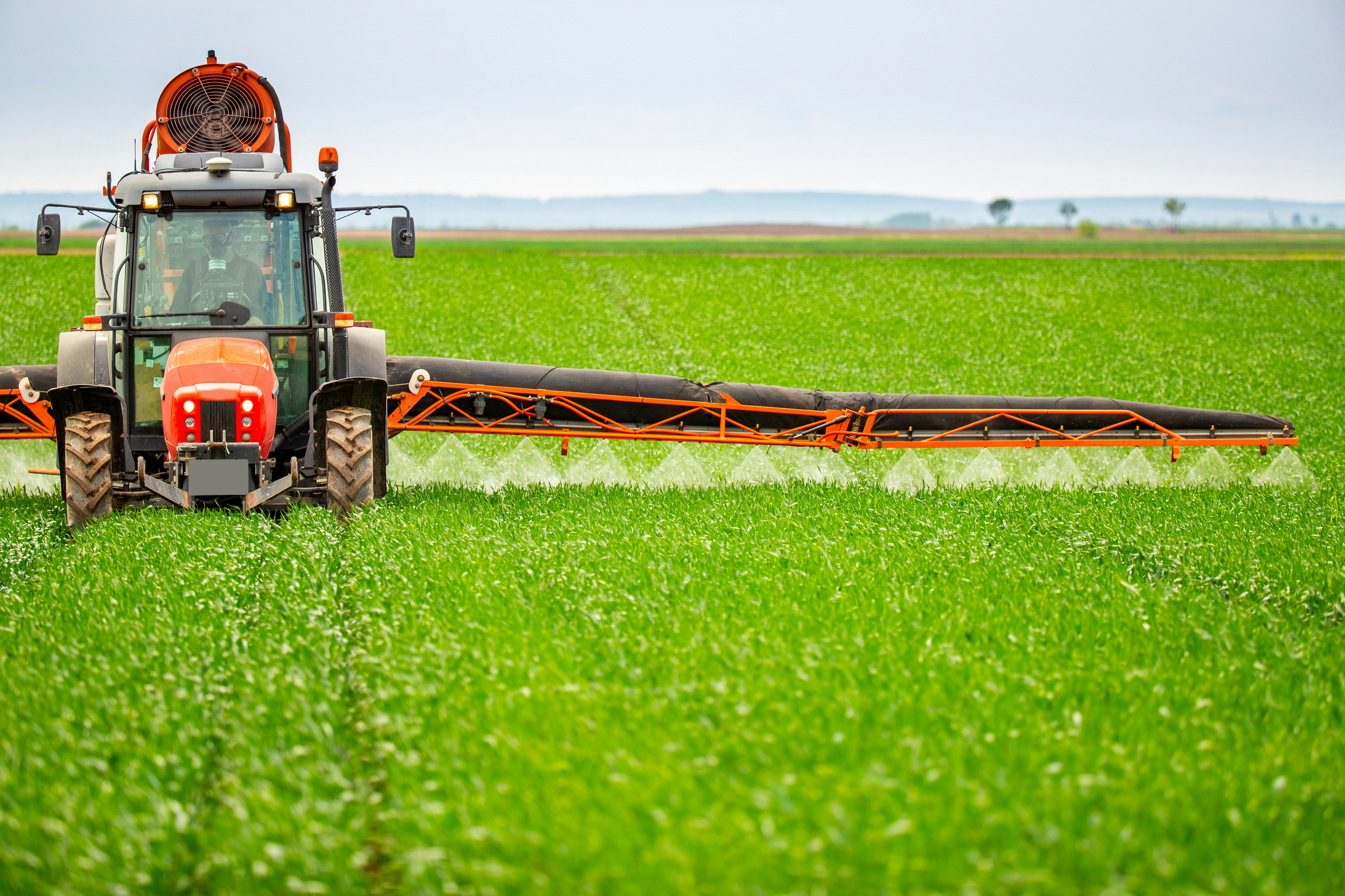 Boom spray tractor working green crop paddock